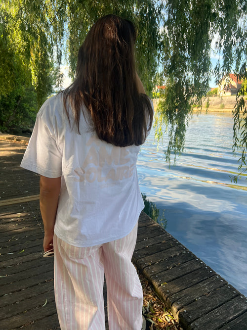 Dos d'un t-shirt blanc manches courtes avec inscription rose